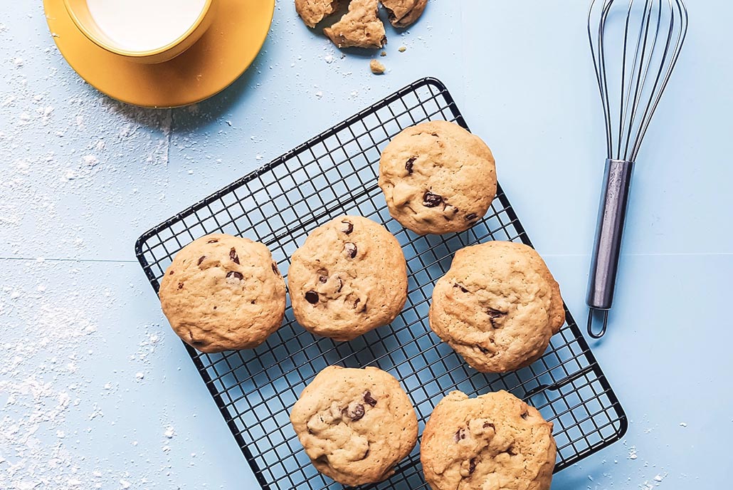 baked cookies on table with whisk and milk