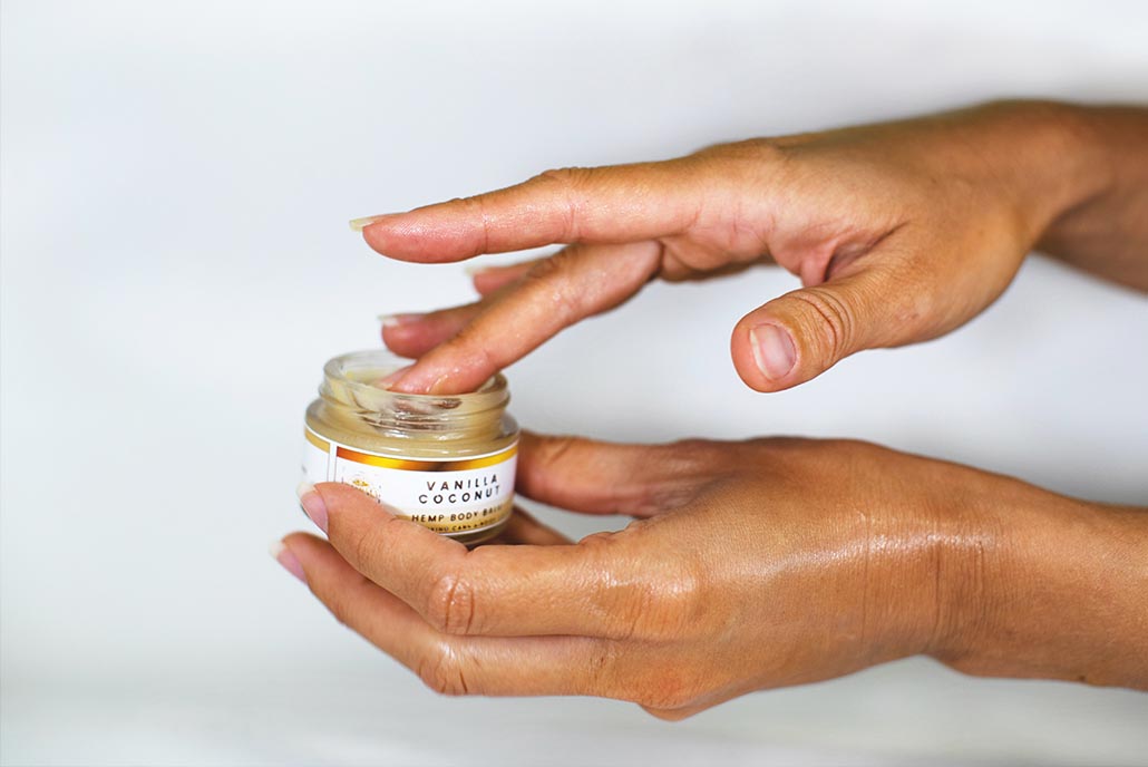 girl putting cbd balm on hands to relax and de-stress
