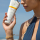 girl holding sunscreen benefits to wearing sunscreen