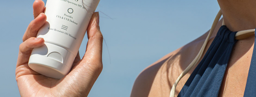 girl holding sunscreen benefits to wearing sunscreen