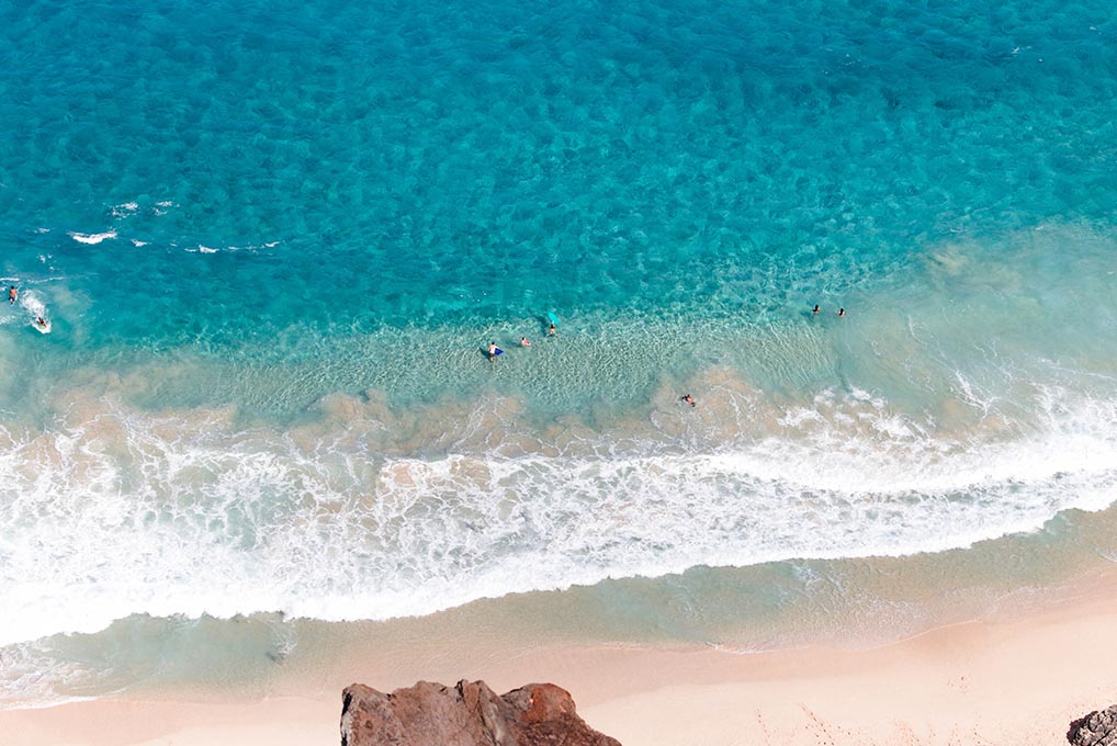 people swimming on beach in hawaii